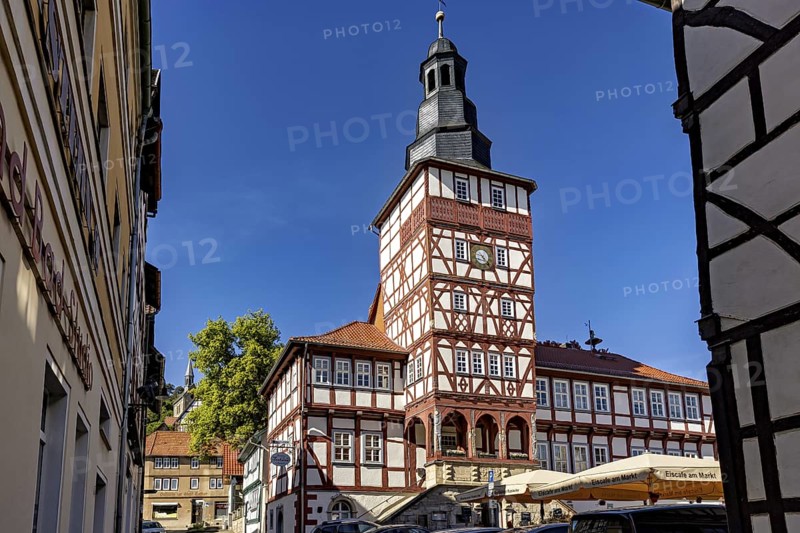 Half-timbered tower and surrounding buildings, seen through a narrow alley under a blue sky, The town hall of Treffurt in Thuringia