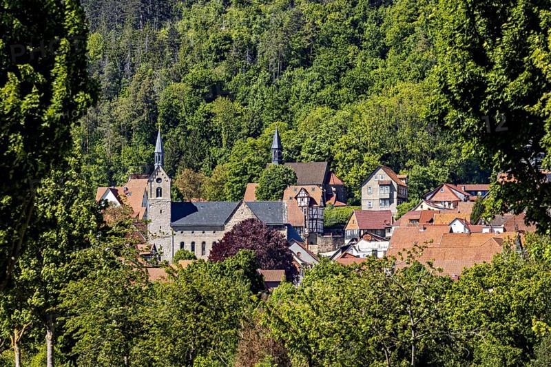 Idyllic village with a church and surrounded by green hills and dense forests, the town of Treffurt in Thuringia
