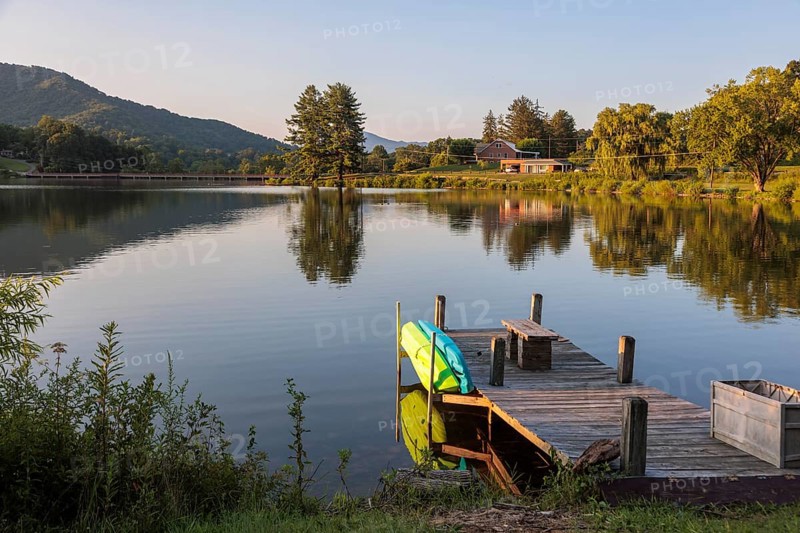 Private pier with a bench, kayak and paddleboard on the lake at Lake Junaluska, North Carolina