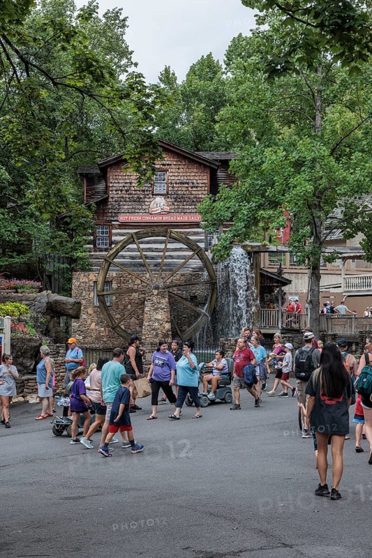 Park guests walking past the Dollywood Grist Mill at the Dollywood amusement park in Pigeon Forge, TN