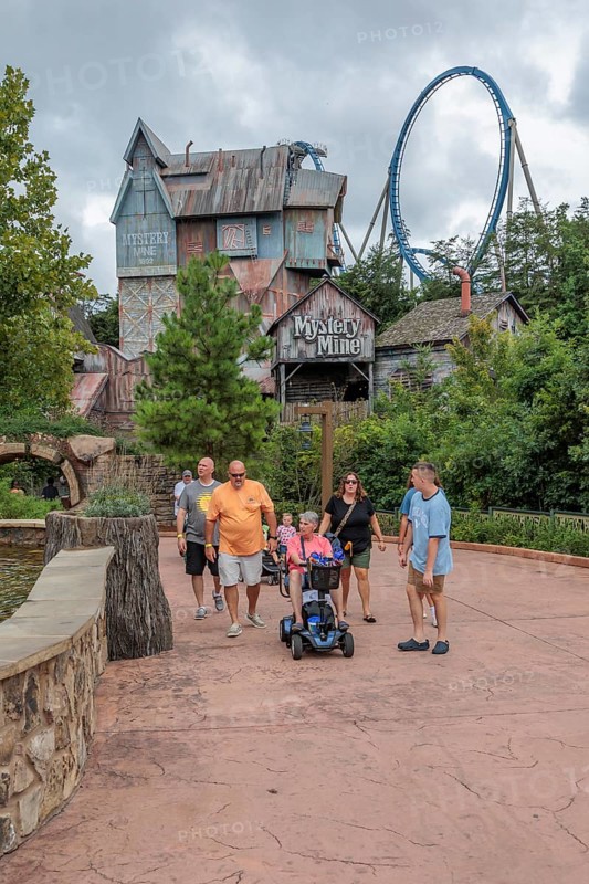 Family of park guests walking past the Mystery Mine roller coaster ride at the Dollywood amusement park in Pigeon Forge, TN