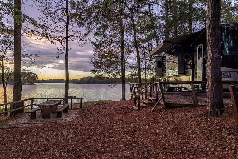 Motorhome parked on the shores of Archusa Creek Lake at sunset in Archusa Creek Water Park near Quitman, Mississippi