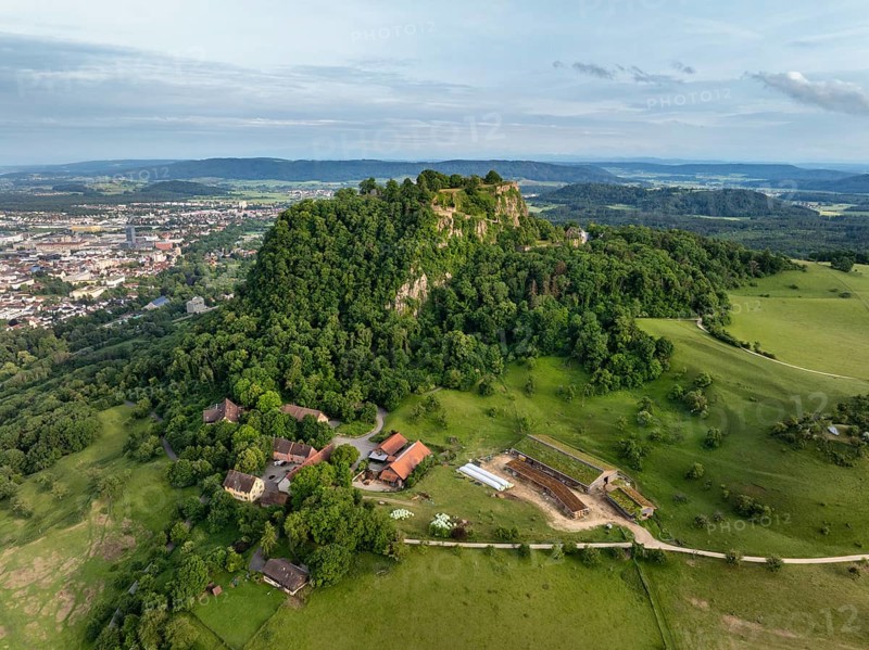 Luftbild vom Vulkankegel Hohentwiel mit der Burgruine, darunter die Domäne, Hofsiedlung, links die Stadt Singen am Hohentwiel, Landkreis Konstanz, Baden-Württemberg, Deutschland