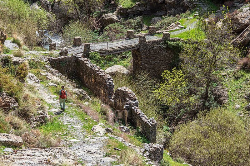 At village Busquistar, hiking path in the gorge of river Trevelez, hiking woman, bridge, Sierra Nevada, Andalusia, Spain