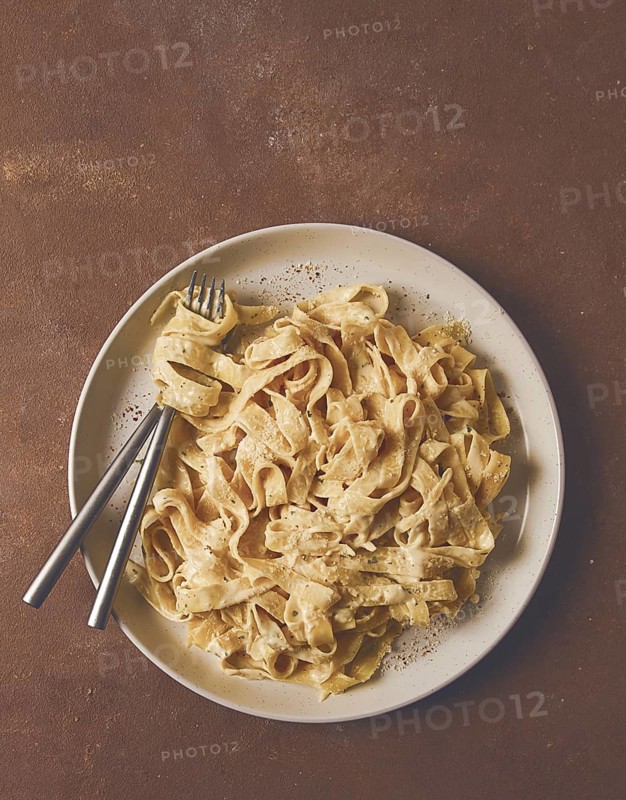 Fettuccine, tagliatelle, in creamy garlic sauce, Italian traditional cuisine, pasta carbonaro