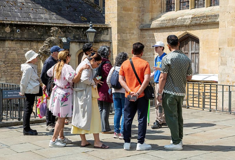 Tour guide with group people at Bath Abbey church, city of Bath, north east Somerset, England, UK