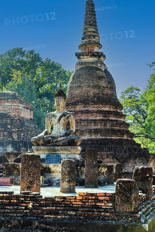 Stone Buddha statue and historic temple tower, Prang, historical park, Sukhothai, Sukhothai province, Thailand