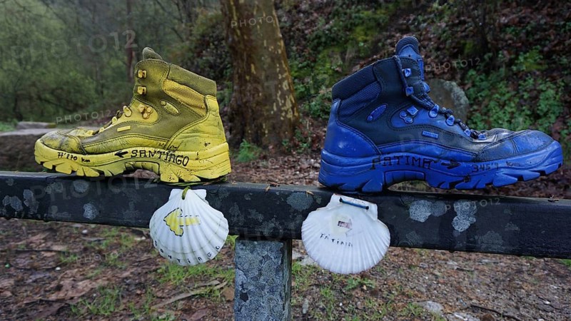 Two hiking boots on a railing decorated with shells, as a guide to Santiago and Fatima, make a pilgrimage on the Caminho Portugues, Portugal, Spain