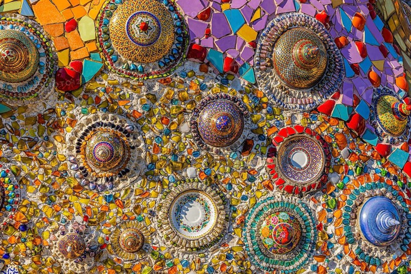 A wall decorated with colorful mosaic tiles and glass works of art, Buddhist temple complex Wat Phra That Sorn Kaew, Phetchabun province, Thailand