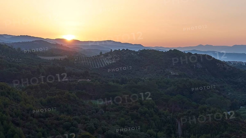 Wide landscape with hills at dusk, sunset behind the mountains, Hotel Europa, garden restaurant and view of the surrounding landscape, Olympia, Peloponnese, Greece