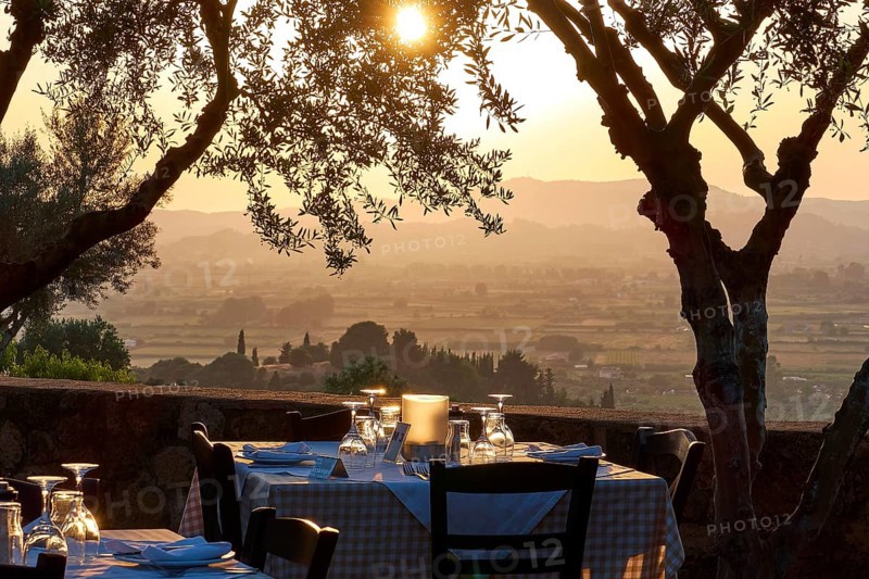 A set table under trees with a view of a vast landscape at sunset, Hotel Europa, garden restaurant and view of the surrounding landscape, Olympia, Peloponnese, Greece