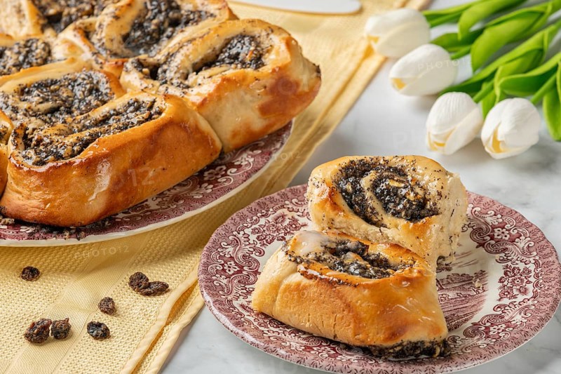 Freshly baked poppy seeds on a plate, next to tulips