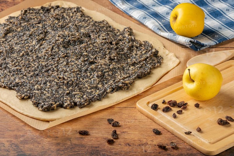 Rolled dough with evenly distributed mixture of poppy seeds, raisins and apples
