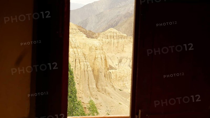 View from a dark window of a rocky, desert-like mountain landscape, trekking in Ladakh, Himalayas, India