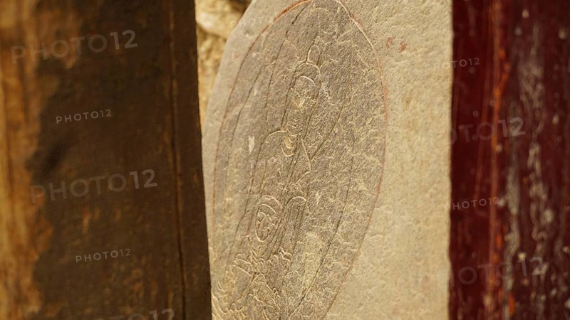 A stone slab with carved Buddha relief as a sacred work of art, trekking in Ladakh, Himalayas, India