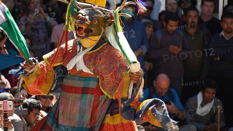 Masked dancer in traditional clothing in front of an audience in Leh, trekking in Ladakh, Himalayas, India
