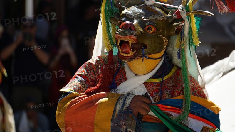 Person in traditional costume with mask dance in festive atmosphere, Leh, trekking in Ladakh, Himalayas, India