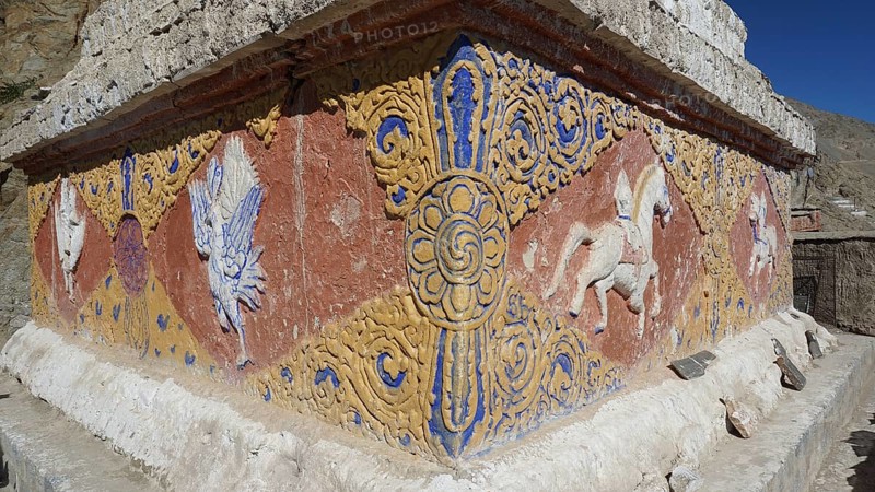 An artfully decorated relief with colorful patterns and symbols on a stone wall, Leh, trekking in Ladakh, Himalayas, India