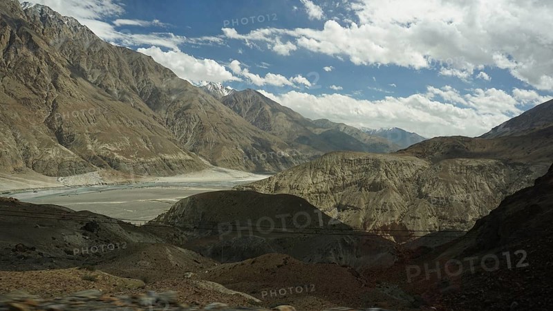 Wide mountain landscape under a cloudy sky with rocky slopes and a valley, trekking in Ladakh, Himalayas, India