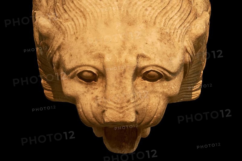 Stone lion head with expressive facial features and open snout on dark background, Olympia Archaeological Museum, Ancient Olympia, Olympia, Peloponnese, Greece