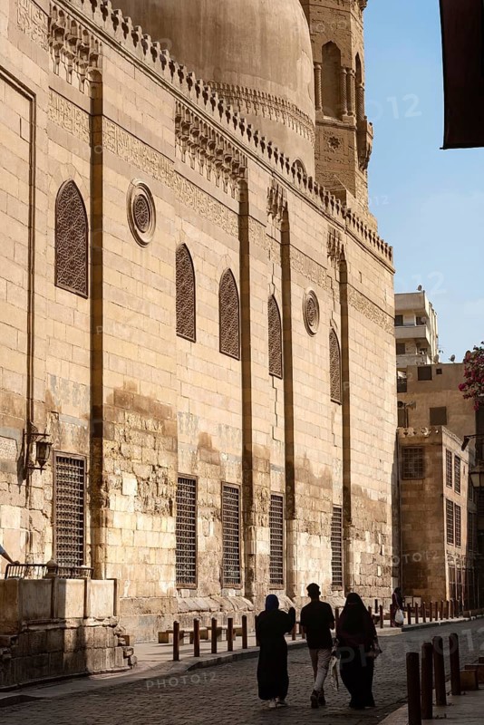 Local tourists walk past one of the many restored monuments along Sharia Al Muizz Li Din Allah near Khan El Khalili Bazaar, historical Cairo, Egypt