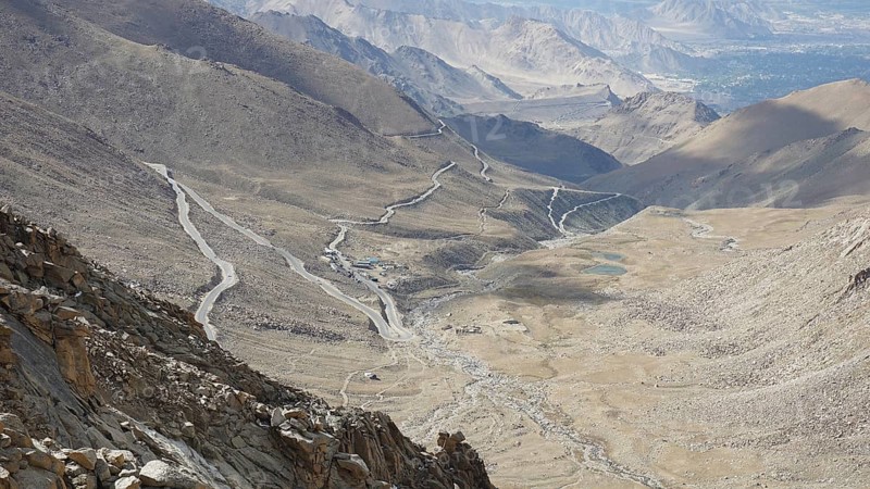Serpentine road snakes through barren valleys and mountains, on the way to Nubra Valley, trekking in Ladakh, Himalayas, India