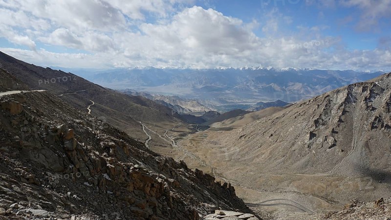 Barren mountain panorama with winding roads under a cloudy sky, trekking in Ladakh, Himalayas, India