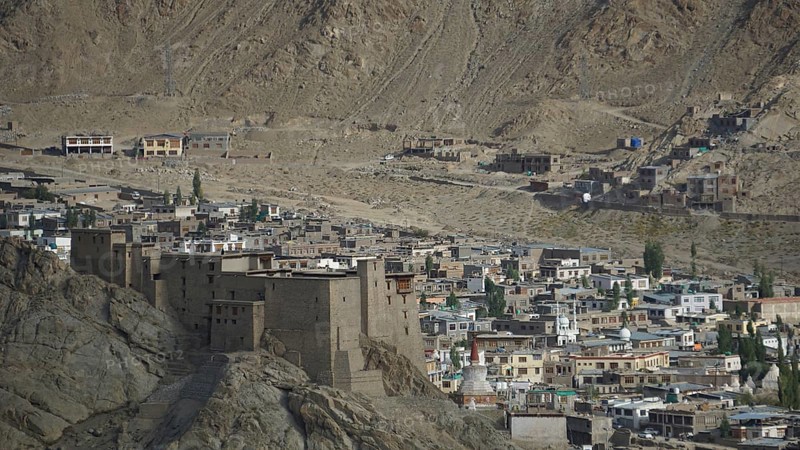 View of the Leh Palace from a hill with Leh in the background in a desert-like environment with traditional buildings, trekking in Ladakh, Himalayas, India