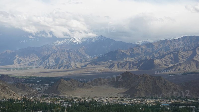 Wide mountain landscape with cloudy sky and distant snow-capped peaks, trekking in Ladakh, Himalayas, India