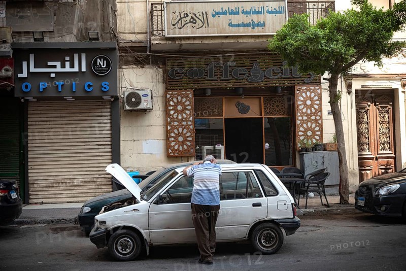Cairo, Egypt. June 24th 2024 An Egyptian man waits by his broken down car in the summer heat of Downtown Cairo, Egypt