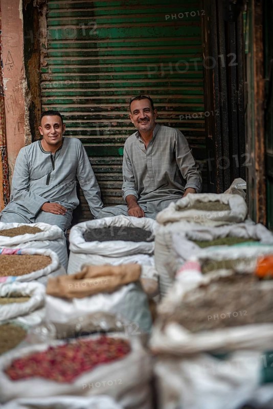 Cairo, Egypt. July 1st 2024 Two Egyptian men sit amongst sacks of spices in the Cairo spice market near the busy Khan el Khalili shopping bazaar, popular with locals and tourists. Egypt