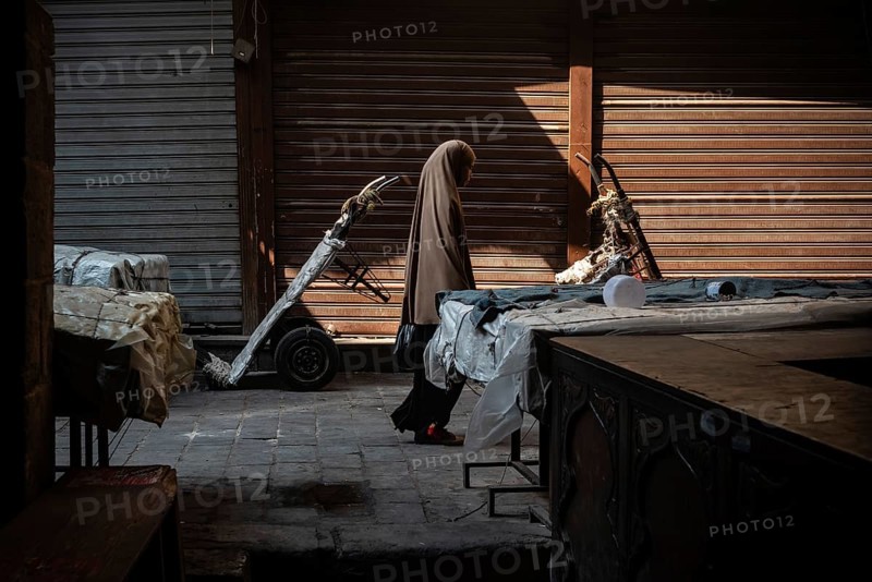 Cairo, Egypt. July 1st 2024 An Egyptian Muslim woman walks along the cobbled streets of a closed market near the Al Ahzar Mosque in Midan Hussein, Islamic Cairo, Egypt