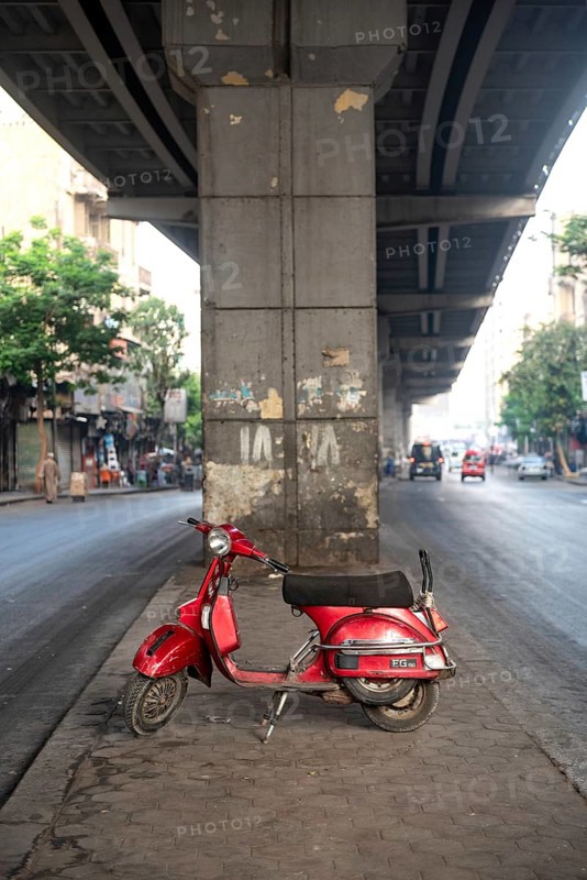 Cairo, Egypt. July 1st 2024 A cool looking red scooter parked under a concrete flyover in the Downtown district of the Egyptian capital, Cairo