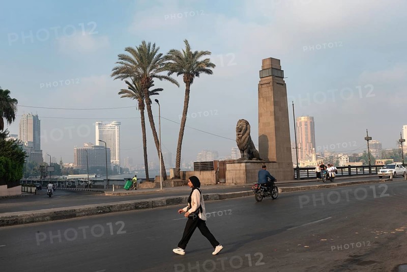 Cairo, Egypt. July 1st 2024 A young muslim Egyptian woman crosses Qasr El Nile Bridge in the early morning, Downtown Cairo, Egypt