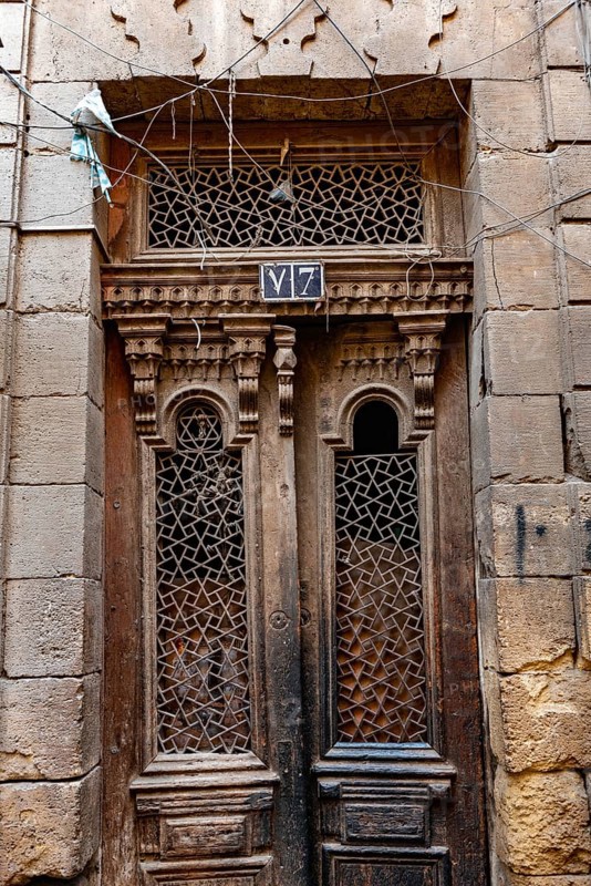 Cairo, Egypt. December 21st 2022 An antique wooden door of a house in the narrow alleyways of the old part of Islamic Cairo nr Khan el Khalili Bazaar, Al Muizz Street, Cairo, Egypt