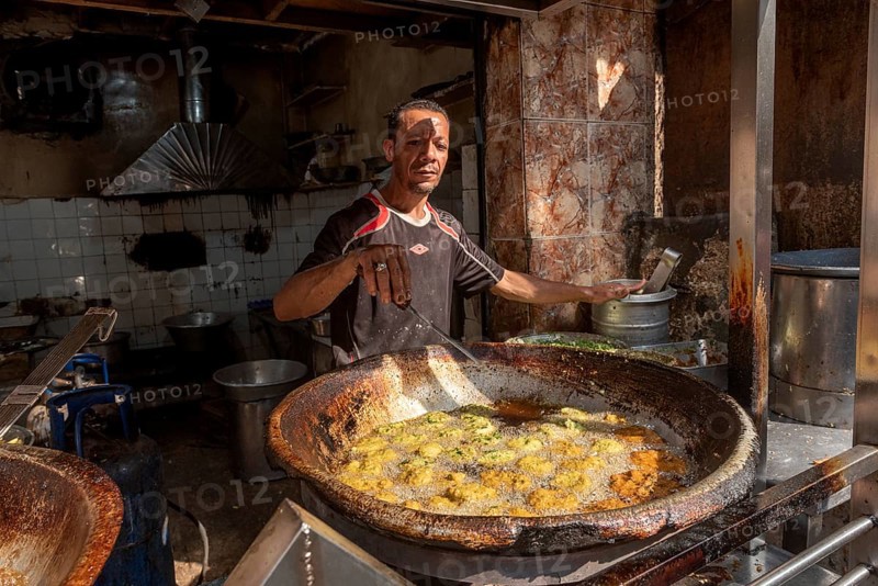 Cairo, Egypt. November 26th 2022 An Egyptian man deep frying Falafel, a chickpea and herb filled snack popular in Egypt and all over the Middle East at his shop in the Islamic Quarter of Cairo, Egypt