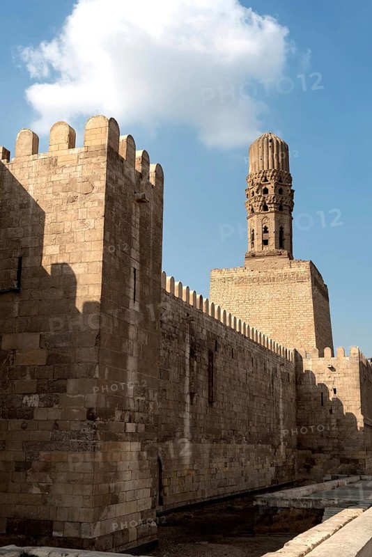 Cairo, Egypt, November 26th 2022 Minaret of the Al Hakim Mosque with the fortified defensive Northern walls of Islamic Cairo, near Bab El Futuh one of the ancient gates of the historical Egyptian city of Cairo, Egypt
