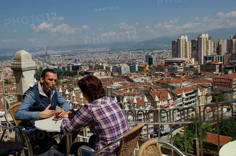 Bursa, Turkey. April 21st 2014 A couple drink tea with the Skyline of the Turkish city of Bursa, Turkey