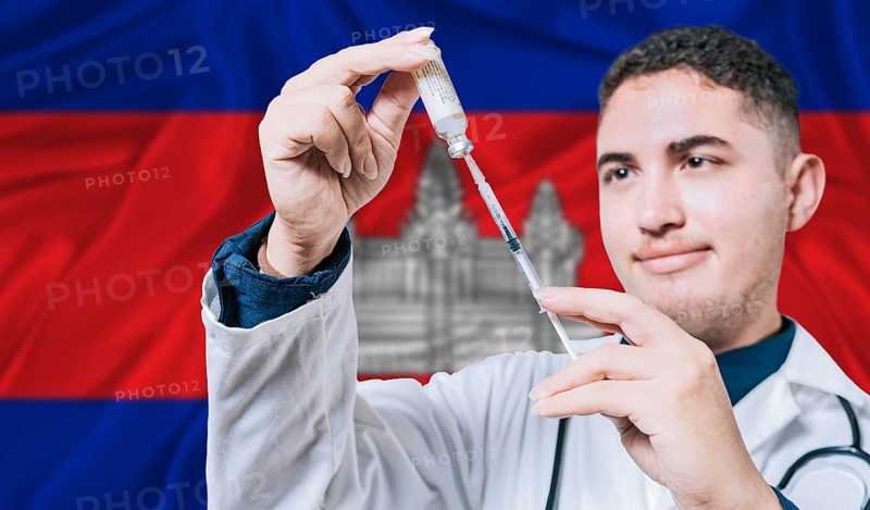 Doctor holding syringe on Cambodia flag background. Medical professional holding syringe with Cambodian flag in the background
