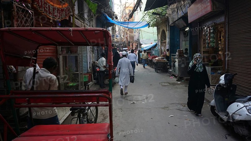 Quiet alley in a Muslim neighborhood of Delhi with isolated people and rickshaws, Delhi, India