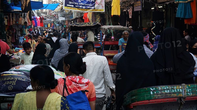 Dense crowd in a market scene with lots of rickshaws and hustle and bustle in a Muslim quarter of Delhi, India