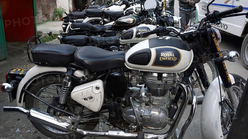 Several parked Royal Enfield motorcycles in a row, Manali, Himachal Pradesh, India