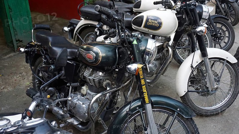 Row of parked Royal Enfield motorcycles in an outdoor area, Manali, Himachal Pradesh, India