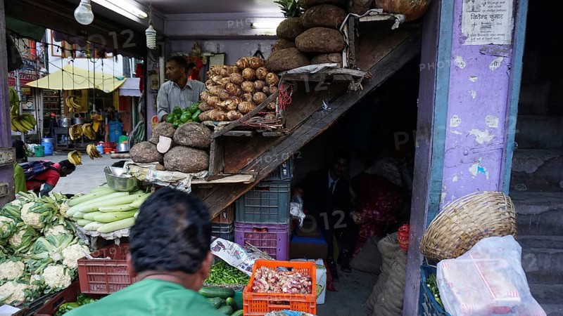 Sales stand at an Indian market with fresh vegetables and visitors, Manali, Himachal Pradesh, India