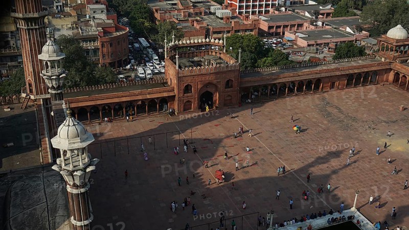 View from above of the Jama Masjid Historic Mosque in an urban setting with people and architectural structures, Delhi, India