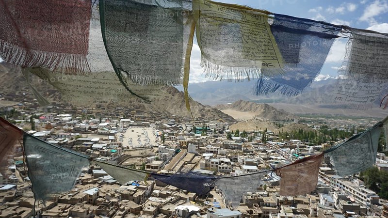Colourful prayer flags waving in the wind, view of Leh Palace and mountains in the background, Ladakh, North India, Himalayas, India