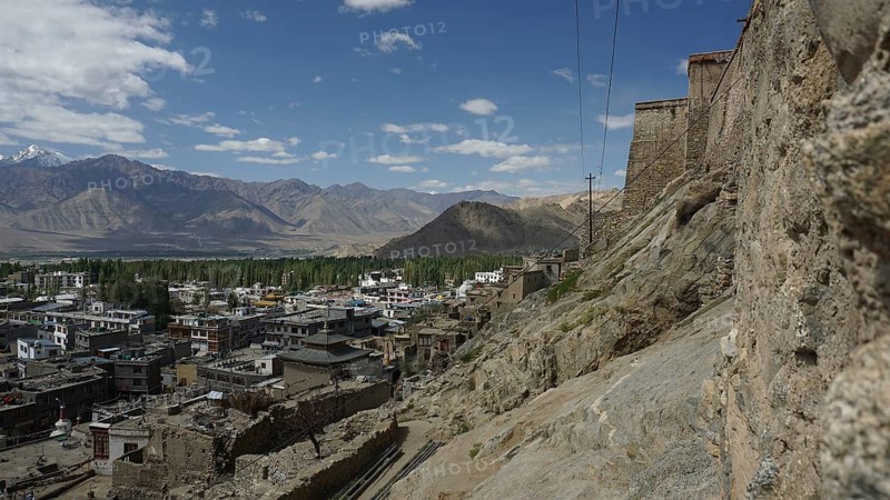 View of Leh on the mountainside with a stone wall and clouds in the sky, view from Leh Palace to Leh, Ladakh, North India, Himalayas, India