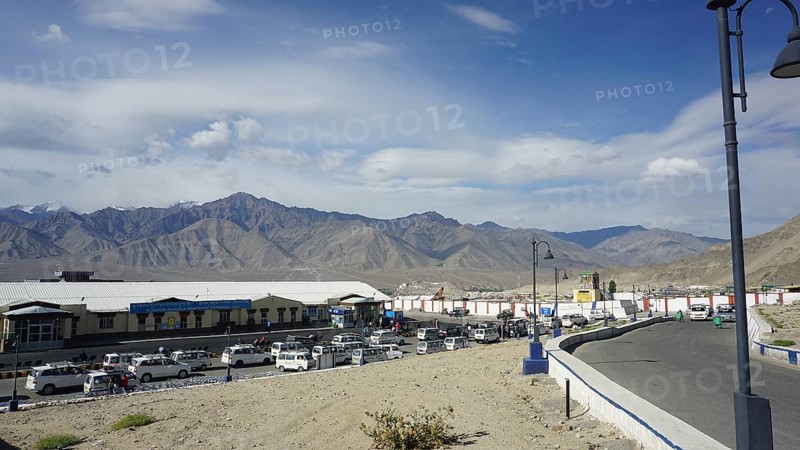 Taxis wait in Leh at the airport in front of surrounding mountains under a clear sky, Leh, Ladakh, North India, Himalayas, India