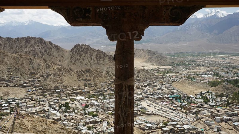 Spectacular mountain view through wooden column with city view under the sky tent, Ladakh, Himalayas, India