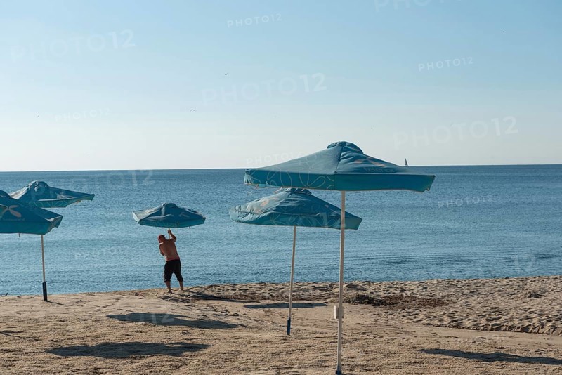 Varna, Bulgaria. September 5th 2020 Setting out sunshade umbrellas on the beach in Varna on the Black Sea coast of Bulgaria